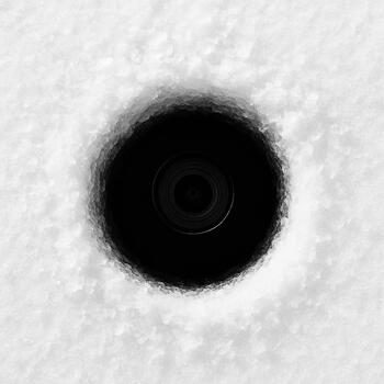 View from above showing an ice hole and a camera cable disappearing below